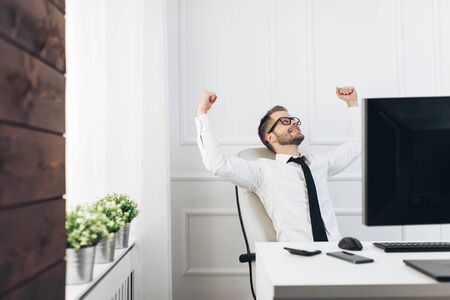 Successful handsome businessman sitting in his officeの写真素材