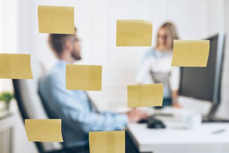 Businesspeople working at the office behind a glass wallの写真素材