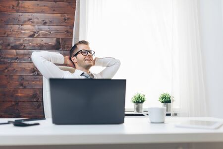 Successful handsome businessman sitting in his officeの写真素材