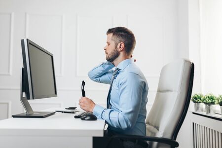 Office worker with back pain from sitting at desk all dayの写真素材