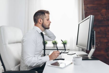 Office worker with back pain from sitting at desk all dayの写真素材