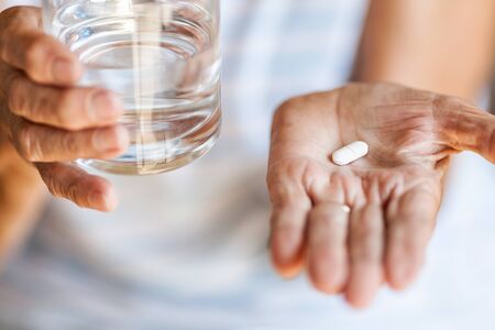 Senior woman taking her daily prescripted medicationの写真素材