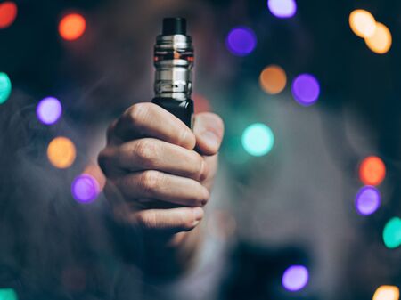 Vaping flavored e-liquid from an electronic cigaretteの写真素材