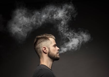 Vaping flavored e-liquid from an electronic cigaretteの写真素材