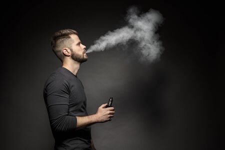 Vaping flavored e-liquid from an electronic cigaretteの写真素材
