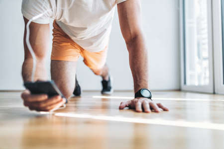 Handsome young man working out at home with a smart watch