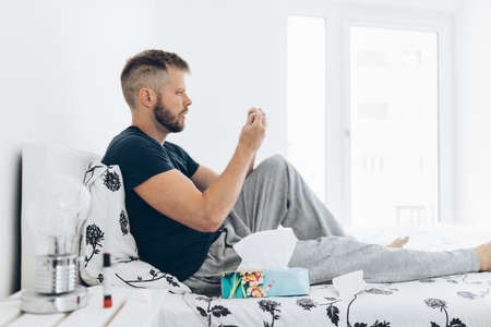 Young man in home quaratine after positive Covid 19 testの写真素材