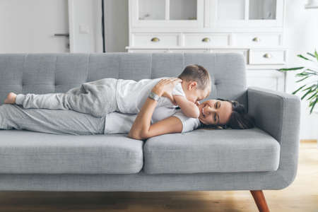 Mother with her son on a sofa in their living roomの写真素材