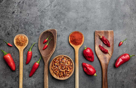 Variety of fresh and dried chili peppers on rustic backgroundの写真素材