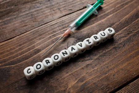 Corona virus Covid-19 vaccine text on wooden backgroundの写真素材