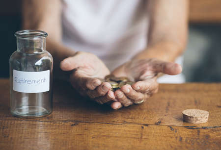 Elderly retired woman and her savings in a jar