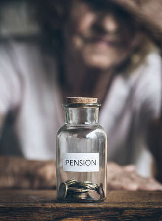Elderly retired woman and her savings in a jarの写真素材