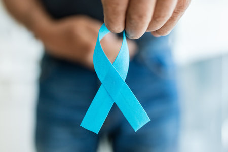 Senior man holding a blue cancer awareness ribbon in handの写真素材