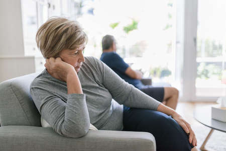 Upset senior couple at home in living room having an argumentの写真素材