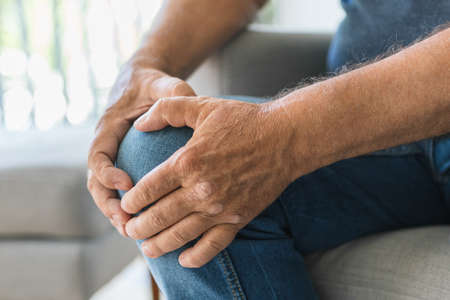 Senior man holding his painful kneeの写真素材