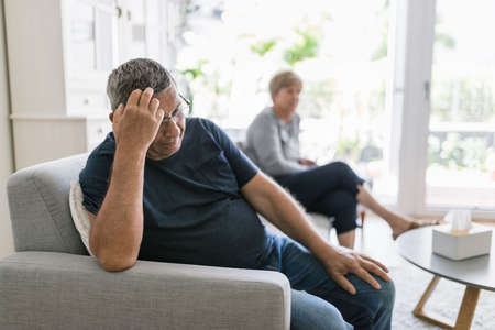 Upset senior couple at home in living room having an argumentの写真素材