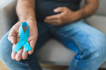 Senior man holding a blue cancer awareness ribbon in handの写真素材