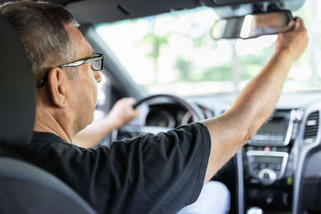 Happy senior in his 70s driving a carの写真素材