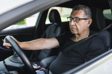 Happy senior in his 70s driving a carの写真素材