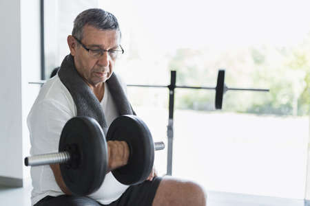 Active and healthy senior exercising in a gymの写真素材