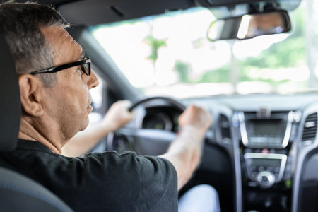 Happy senior in his 70s driving a carの写真素材