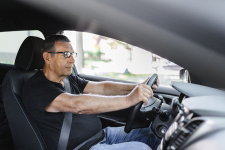 Happy senior in his 70s driving a carの写真素材