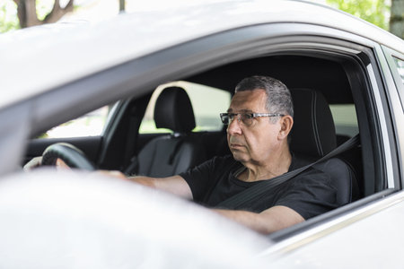 Happy senior in his 70s driving a carの写真素材