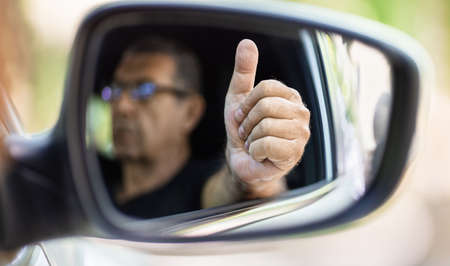 Happy senior in his 70s driving a carの写真素材