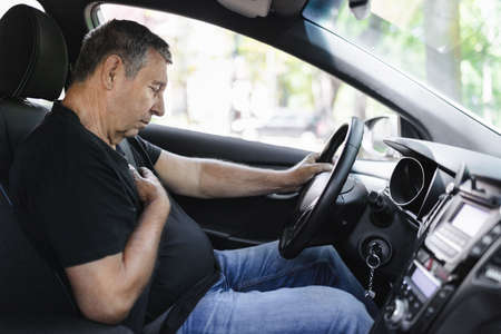 Senior in his 70s, behind the steering wheel with chest painの写真素材