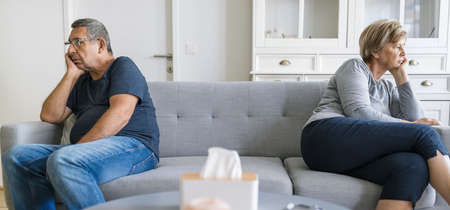 Upset senior couple at home in living room having an argumentの写真素材