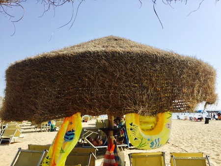 The man is sleeping under his sun umbrella (Pesaro, Italy)の写真素材