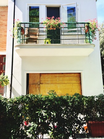 Wooden door and a balcony of a white house - Building façade (Pesaro, Italy)の写真素材