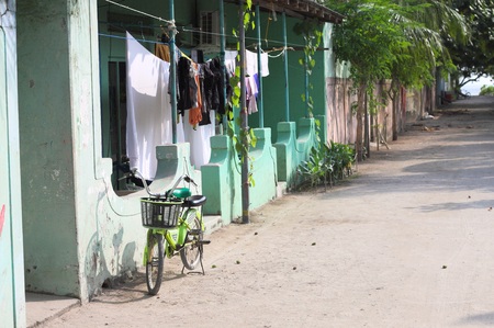 Isolated green bike on the street of a Maldivian village (Ari Atoll, Maldives)の写真素材