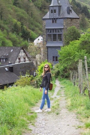 Bacharach, Germany - April 25, 2019: Isolated blonde girl walking in a vineyard