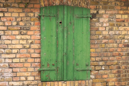 Isolated green wooden window in a brick wallの写真素材