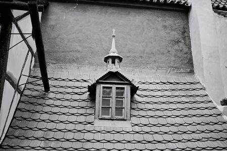 Isolated gothic and baroque window with a spire in a roof with tiles (Prague, Czech Republic, Europe)の写真素材
