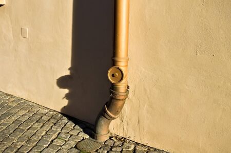 Isolated copper water pipe with a shadow on the wall (Prague, Czech Republic, Europe)