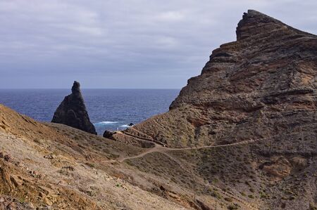 Landscape with cliffs and volcanic rock groynes in the atlantic ocean