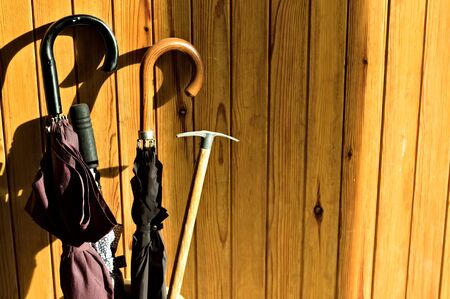 Umbrellas and a pickaxe leaning against a wooden door (Pesaro, Italy, Europe)の写真素材