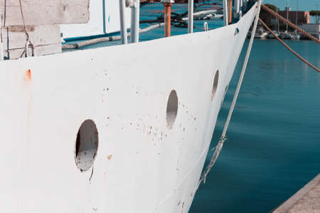 Small portholes of a white fishing boat moored at the port on the Mediterranean sea (Pesaro, Italy, Europe)の写真素材