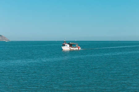 A fishing boat is entering the port in the Mediterranean sea (Pesaro, Italy, Europe)の写真素材
