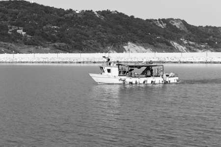 A fishing boat is entering the port in the Mediterranean sea (Pesaro, Italy, Europe)の写真素材