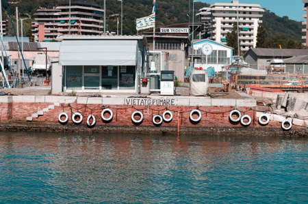 no smoking sign on the harbor pier with many white colored tires (Pesaro, Italy)