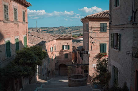 A stairway in a medieval Italian village with an old brick well (Corinaldo, Marche, Italy, Europe)の写真素材
