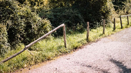 A broken wooden fence next to a dirt road (Gubbio, Umbria, Italy, Europe)