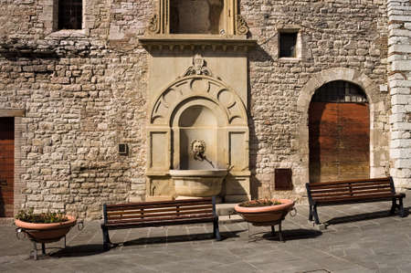 Vases and benches along the street in front of an old building of a medieval Italian village (Gubbio, Umbria, Italy, Europe)の写真素材