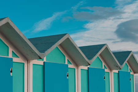 A series of turquoise beach sheds with blue wooden doors in a winter day (Pesaro, Italy, Europe)の写真素材