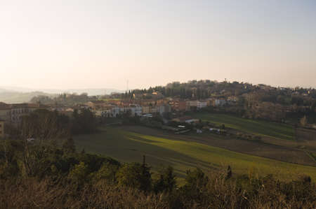 A block of flats in the countryside on a hill at sunset (Marche, Italy, Europe)