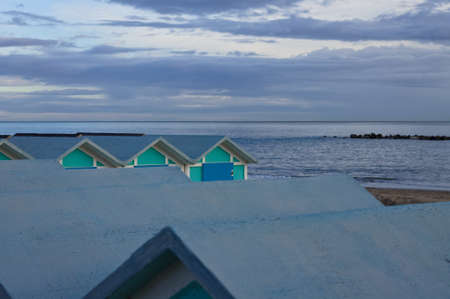 A series of blue beach huts on the Mediterranean coast in the evening hours (Pesaro, Marche, Italy)