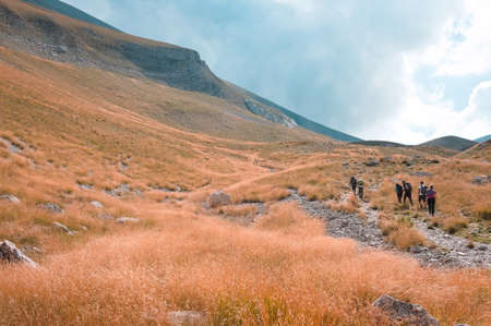 A group of people is trekking in the mountains of the Monti Sibillini National Park (Marche, Italy, Europe)の写真素材